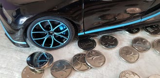 黑布加迪希龙金属玩具特写镜头有站立在小组的蓝色轮子的一以色列锡克尔硬币 免版税库存照片 黑布加迪希龙金属玩具特写镜头有站立在小组的蓝色轮子的一以色列锡克尔硬币 免版税库存照片